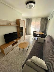 sala de estar con sofá, TV y mesa en Capitan Friday Apartments, en Torrevieja