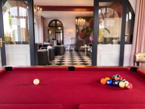 - un billard rouge avec des billes au-dessus dans l'établissement Park Hotel Bellevue, à Trégastel