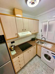 cocina con fregadero y lavadora en Capitan Friday Apartments, en Torrevieja