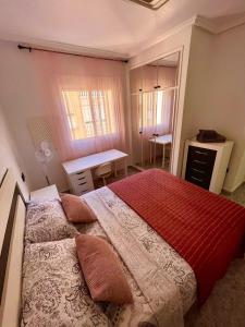 1 dormitorio con 1 cama grande y escritorio en Capitan Friday Apartments, en Torrevieja