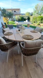 Une table et des chaises en bois sont disponibles sur la terrasse. dans l'établissement L’oliveraie, à Robion