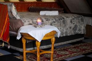 uma vela sentada numa mesa em frente a uma cama em Casa Bena em Maun