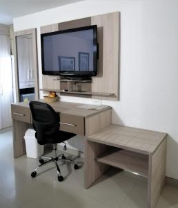 a desk with a chair and a television on a wall at Hotel Panorama in Sincelejo