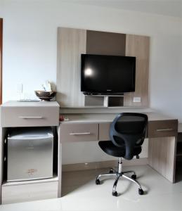 a computer desk with a monitor and a chair at Hotel Panorama in Sincelejo
