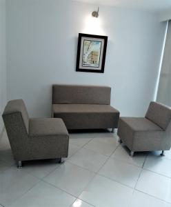 una sala de espera con 2 sillas y un sofá en Hotel Panorama, en Sincelejo