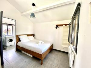 a bedroom with a bed and a washing machine at La Lande - Petite maison avec jardin in Vendat