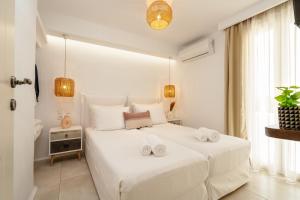 1 dormitorio blanco con 2 toallas blancas en una cama en Santo Concept Luxury Villas en Agia Anna Naxos