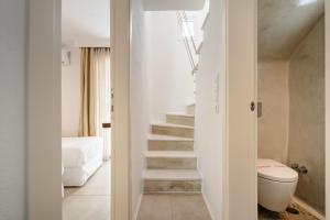 a staircase in a room with a toilet and a bedroom at Santo Concept Luxury Villas in Agia Anna Naxos