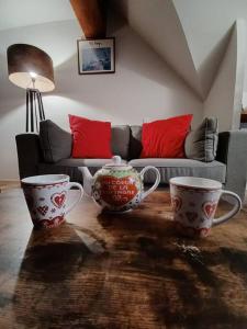 uma sala de estar com duas chávenas de chá e um sofá em Appartement duplex classé 4 étoiles plein centre village em Saint-Lary-Soulan