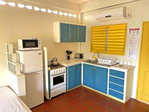 a kitchen with blue cabinets and a white refrigerator at Sherwood Park Apartments in Carnbee Village