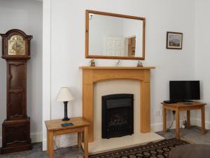 een woonkamer met een open haard en een spiegel bij Chapelhill Hideaway Isle of Bute licence AR00654F in Rothesay