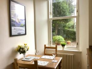 een tafel en stoelen in een kamer met een raam bij Chapelhill Hideaway Isle of Bute licence AR00654F in Rothesay
