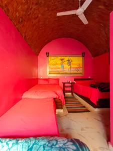 um quarto com duas camas num quarto cor-de-rosa em Kamel House em Aswan