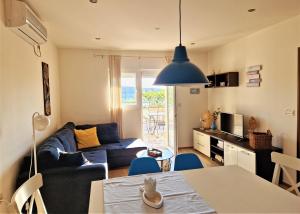 a living room with a blue couch and a table at Villa Petra in Rab