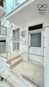 Casa blanca con puerta de cristal y escaleras en Infinity Suite en Peschici