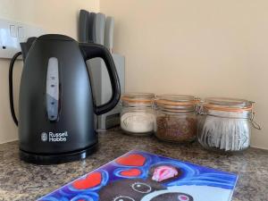 a toaster sitting on a counter next to jars of food at The Byre @ Cow Close - Stay, Rest and Play in the Dales. in Leyburn