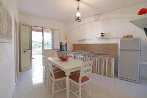 eine Küche mit einem weißen Tisch und einem weißen Kühlschrank in der Unterkunft Torre Santo Stefano in Otranto
