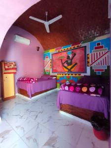 um quarto com duas camas e um quadro na parede em Kamel House em Aswan