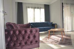 a living room with a purple couch and a table at LOYA APARTMENTs in Trabzon