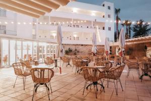 a patio with tables and chairs in a restaurant at Hotel Ankaa - Adults Only in Porto Cristo