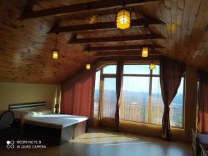 a bedroom with a bed and a large window at Gonio Hills • Batumi in Batumi