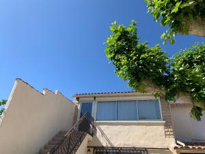 a building with stairs and a blue sky at Le Marcelou in Entraigues-sur-la-Sorgue