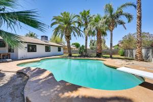 a swimming pool in front of a house with palm trees at Yuma Vacation Rental with Private Pool and Patio! in Yuma