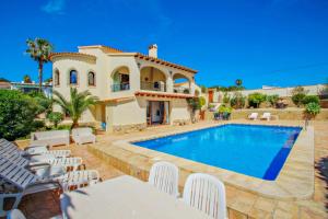 eine Villa mit einem Swimmingpool vor einem Haus in der Unterkunft Alice - holiday home with private swimming pool in Benissa in Benissa