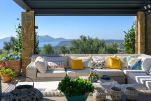 eine weiße Couch auf einer Terrasse mit Kissen in der Unterkunft Luxury Villa Mansion with Extraordinary Sea Views! in Foiníki