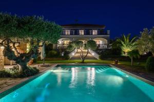 ein Schwimmbad vor einem Haus in der Nacht in der Unterkunft Luxury Villa Mansion with Extraordinary Sea Views! in Foiníki