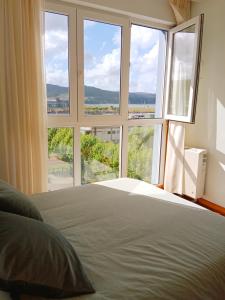 a bedroom with a bed and a large window at El Mirador 2 in Viveiro