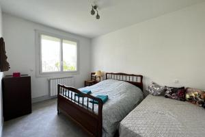 1 dormitorio con 2 camas y ventana en Maison de Famille à Soulier, en Gramat
