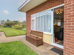 a bench on the side of a house with a window at En-Casa in Norwich