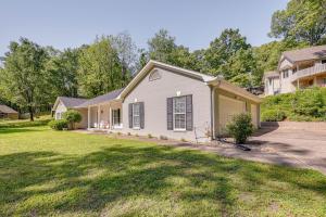 a house with a driveway and a yard at North Bentonville Vacation Rental Near Bike Trails in Bentonville