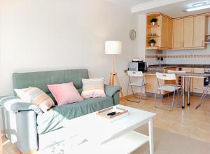 a living room with a green couch and a kitchen at El Mirador 2 in Viveiro