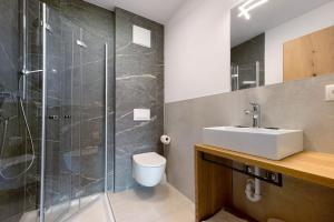 een badkamer met een douche, een wastafel en een toilet bij Haus Mader 2 in Riscone