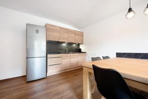 een keuken met een houten tafel en een koelkast bij Haus Mader 2 in Riscone
