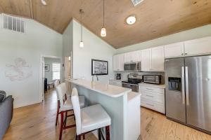 Una cocina con gabinetes blancos y un refrigerador de acero inoxidable. en Eskridge Gem Unit B, en Port Aransas 20 fotos más