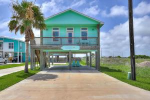 una casa azul con un balcón en una acera en Eskridge Gem Unit B, en Port Aransas