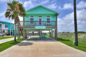 a blue house with a balcony on a sidewalk at Eskridge Gem Unit B in Port Aransas