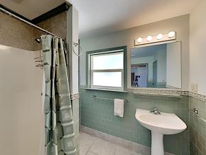 a bathroom with a sink and a mirror at Sea'Scape in Pensacola Beach