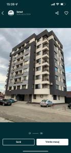 un grande edificio con auto parcheggiate di fronte di CONFORT' by J a Iaşi