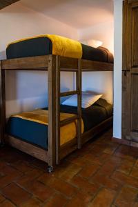 Horta da Quinta في ميرتولا: يوجد سريرين بطابقين في غرفة مع أرضية من الطوب