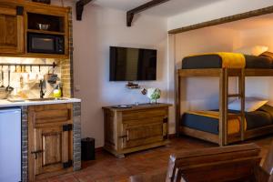 Horta da Quinta في ميرتولا: غرفة بسريرين بطابقين ومطبخ