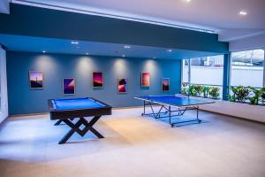 two ping pong tables in a room with paintings at Edificio Acqualina in Quito
