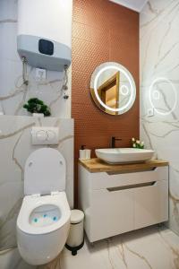 ein Badezimmer mit einem weißen WC und einem Waschbecken in der Unterkunft ETA APARTMENT in Palić