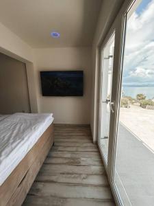 um quarto com uma cama e uma grande janela em Apartment ”Sand” on island Šolta em Nečujam
