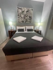 1 dormitorio con 1 cama grande y 2 toallas. en Marina Zeas Seaside Studio-MarinaQ, en Pireo