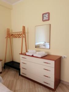 a bedroom with a dresser with a mirror and a bed at Holiday Center Apartment in Shkodër