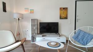 a living room with a tv and two chairs at To Helidoni Apartment & Gardens in Nikiti